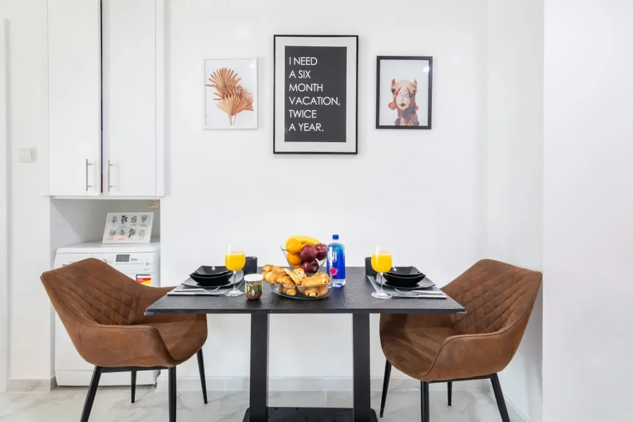 Una mesa de comedor con comida y bebidas está entre dos sillas.