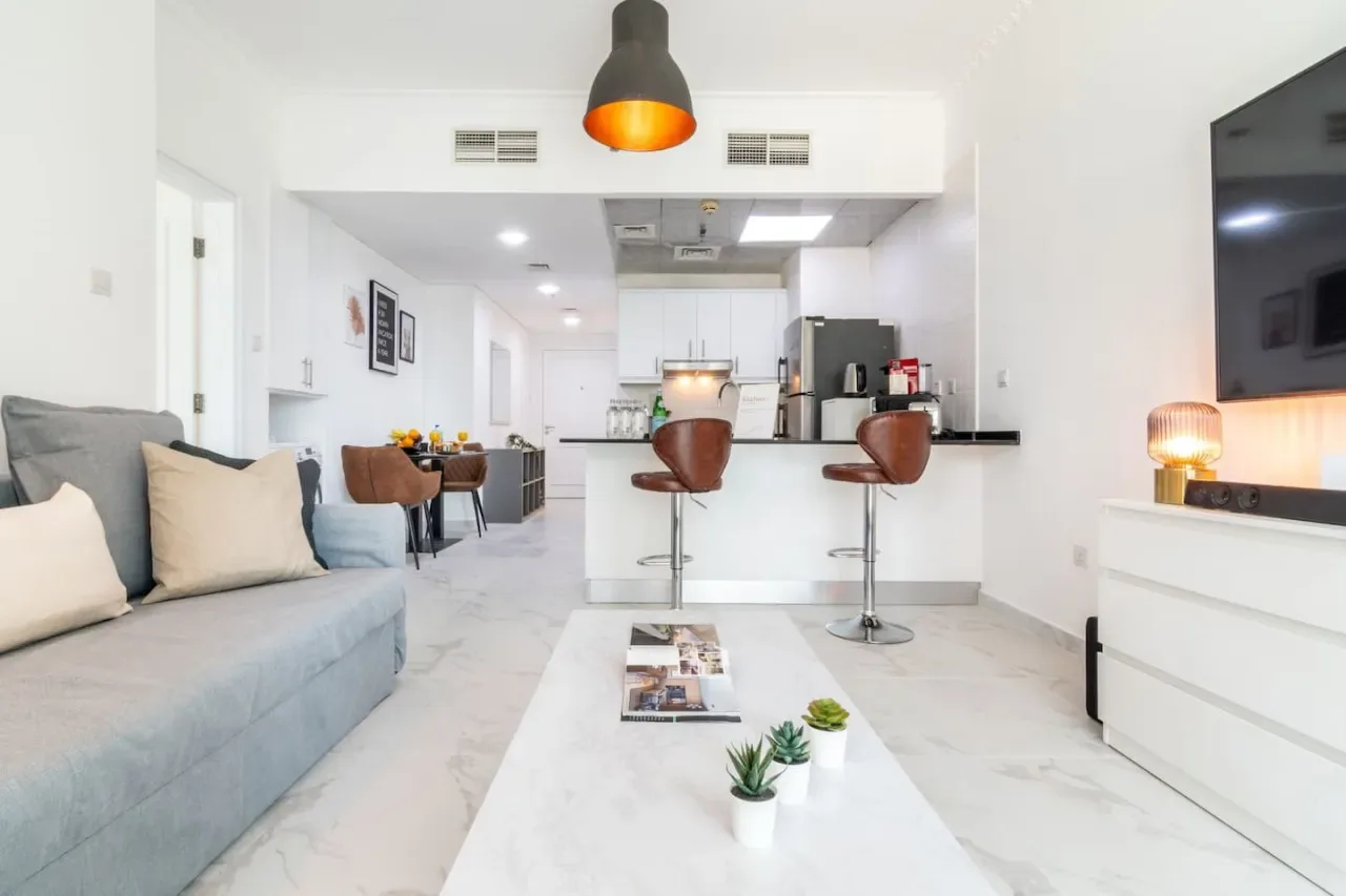 Sala de estar y cocina de concepto abierto con sofá y barra de desayuno.