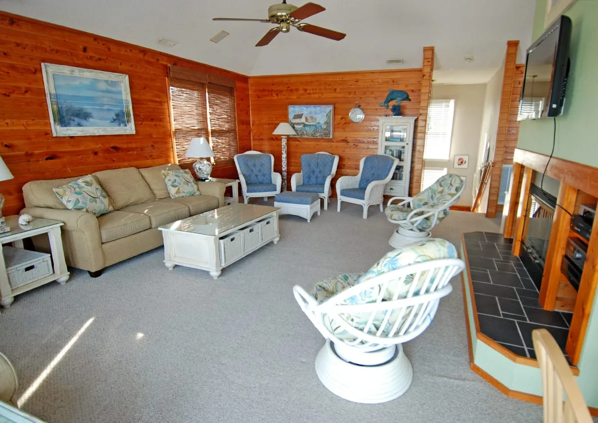 A wood-paneled living room with seating arranged around a coffee table.
