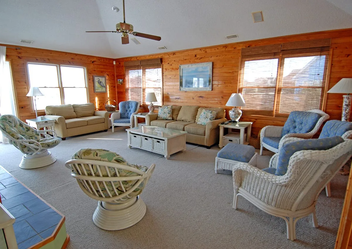 A spacious living room with wicker seating arranged around a coffee table.