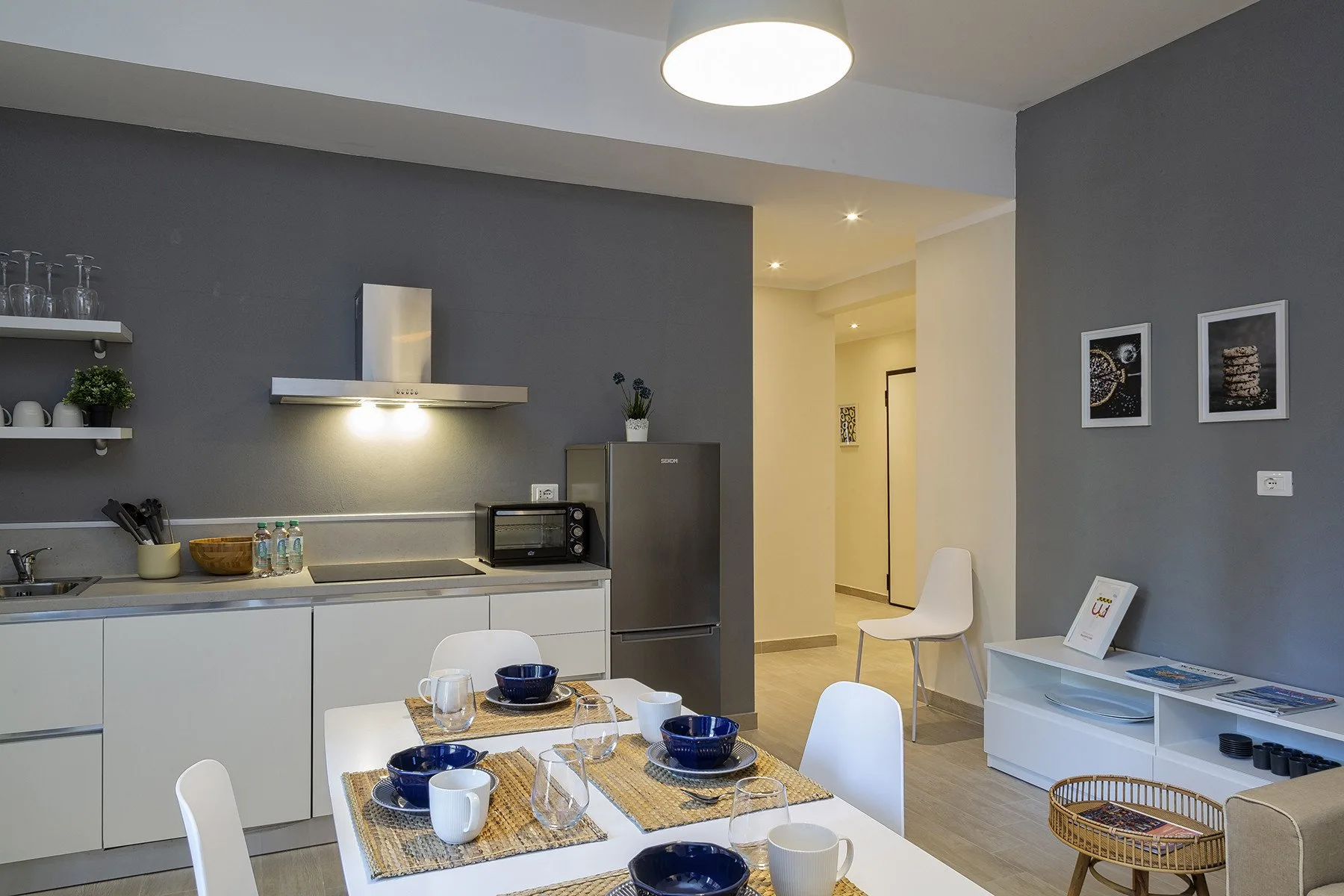 A modern kitchen and dining area with a table set for a meal.