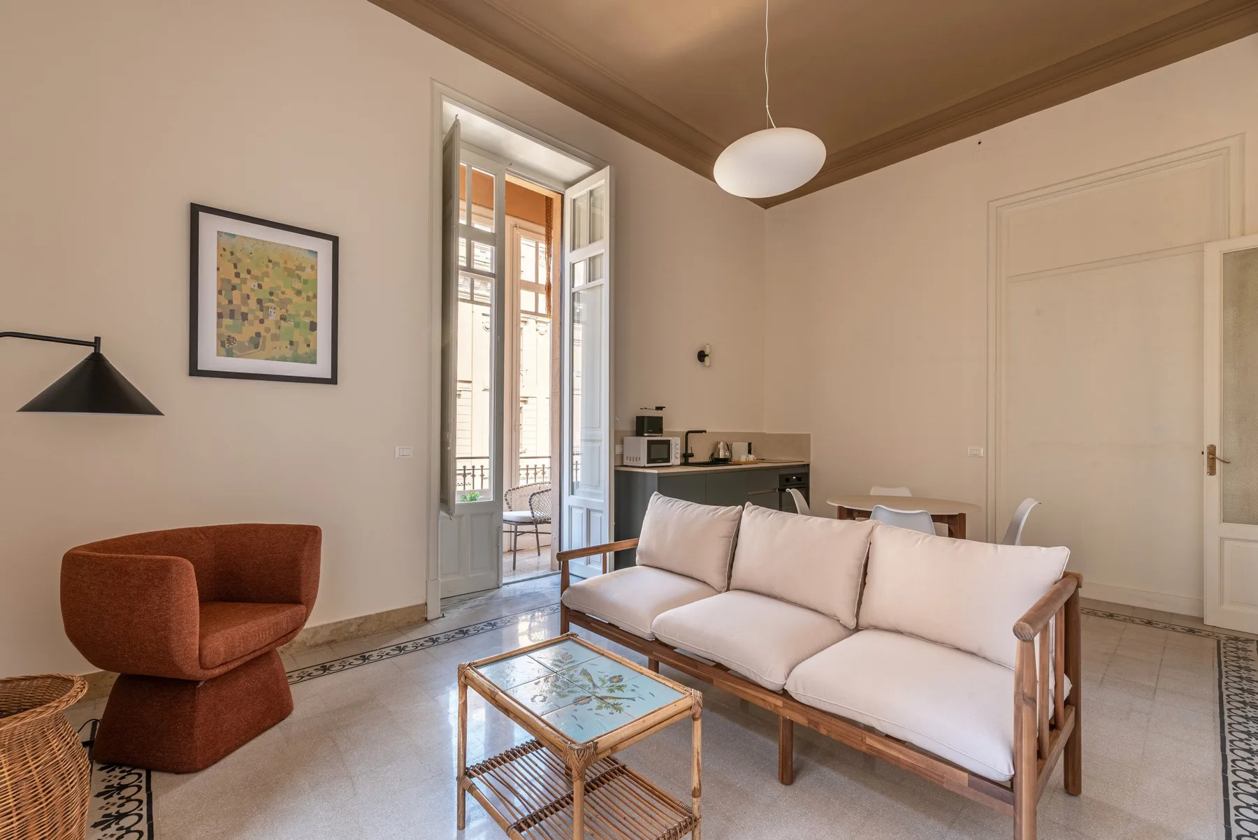 A living room with light-colored seating and open French doors.