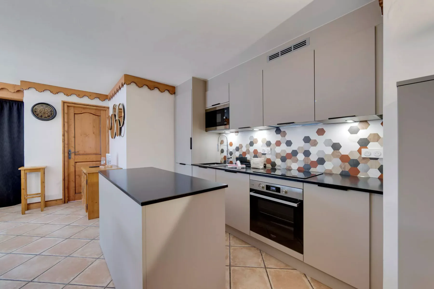 Una cocina moderna con isla, electrodomésticos integrados y un salpicadero estampado.