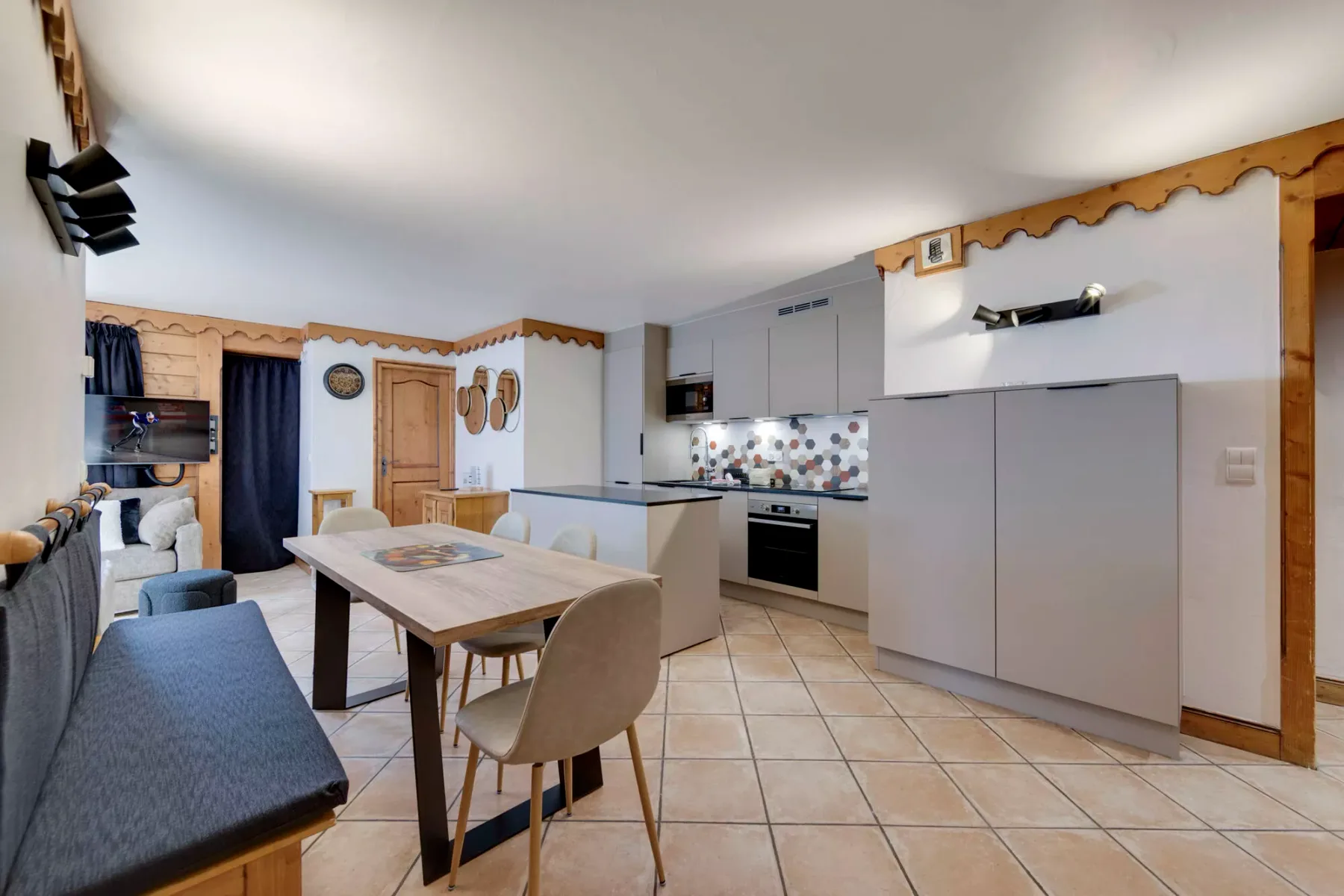Una cocina abierta al comedor, con una mesa y asientos.