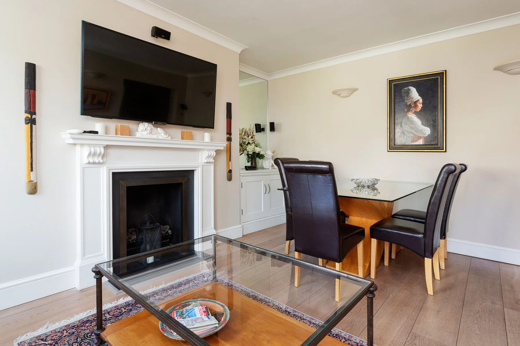 A living and dining area with a fireplace, television, and dining table.