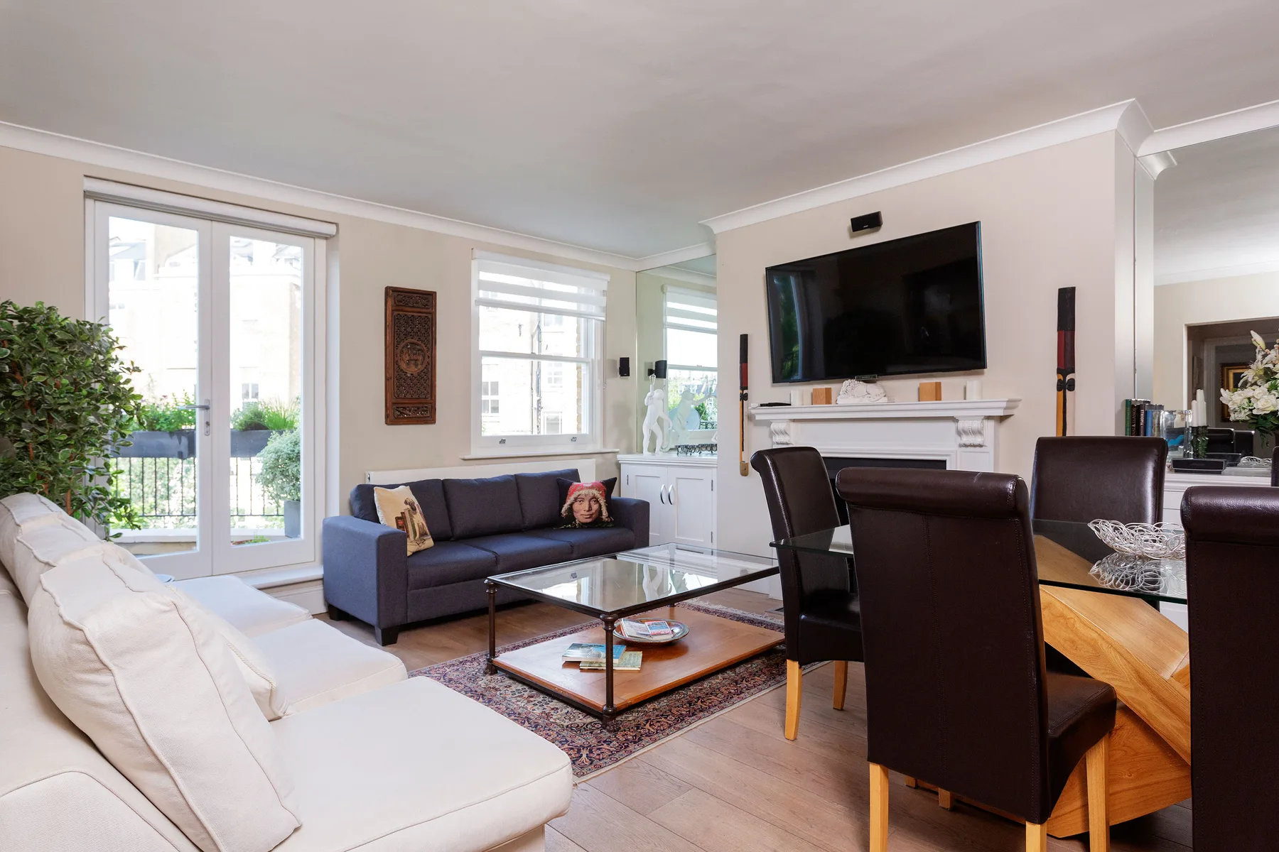 A living room with seating around a coffee table and a wall-mounted television.