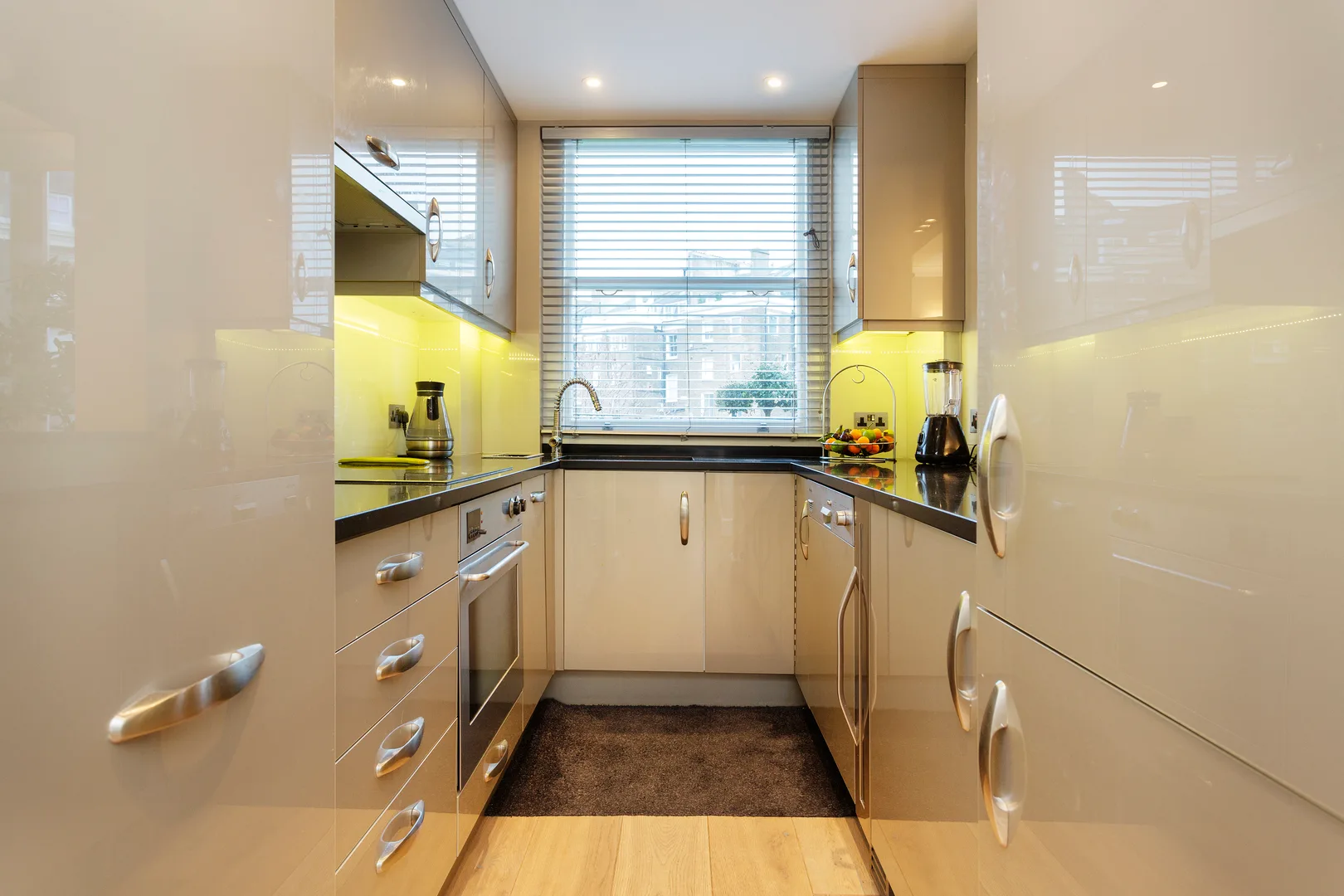 Una cocina compacta con encimeras y armarios alrededor de una ventana.
