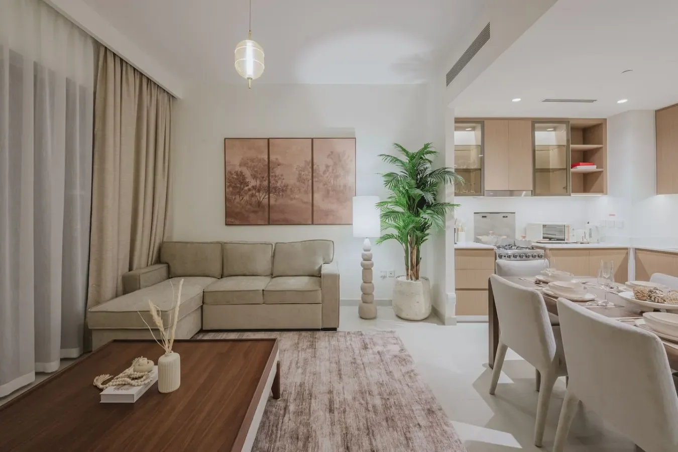 A living and dining area opens onto a kitchen, with seating and a coffee table.