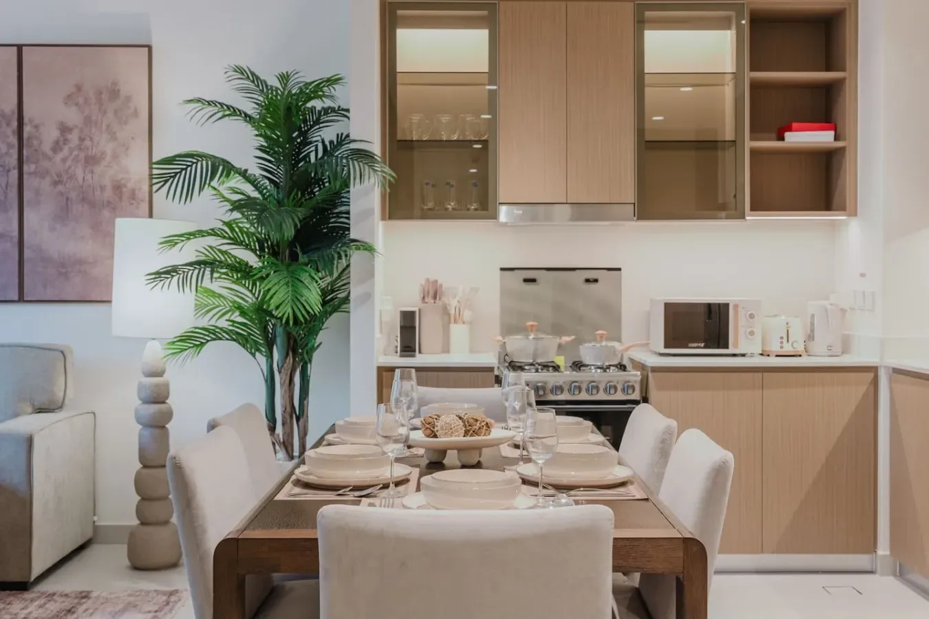 A dining area with a set table beside a kitchen.