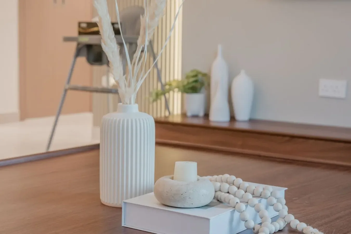 A decorative arrangement sits on a low table in a softly lit room.