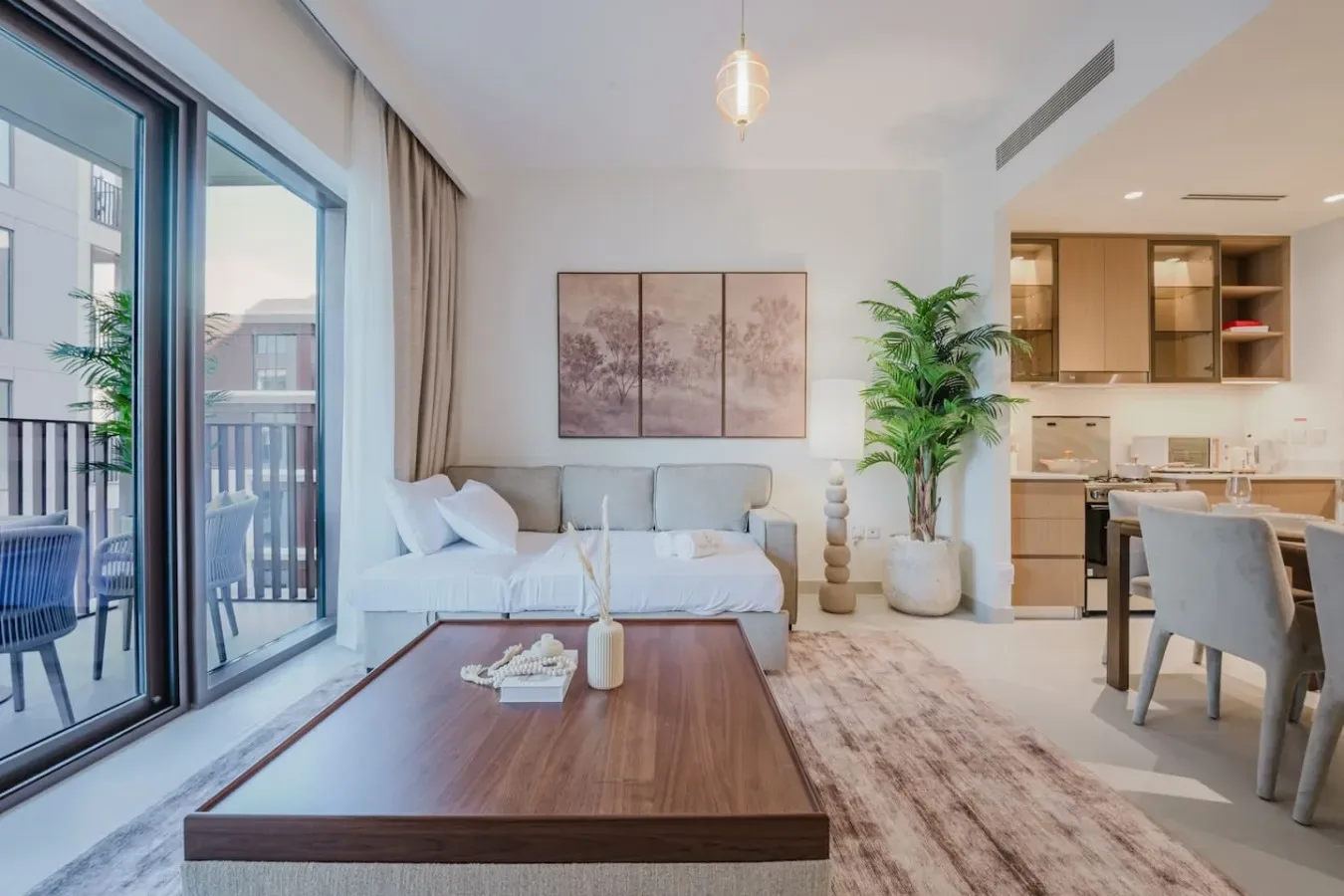 A bright living area with seating, a coffee table, and an open kitchen.