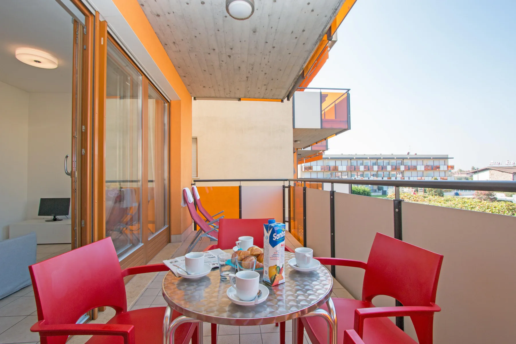 A balcony seating area with a round table and sliding glass doors.