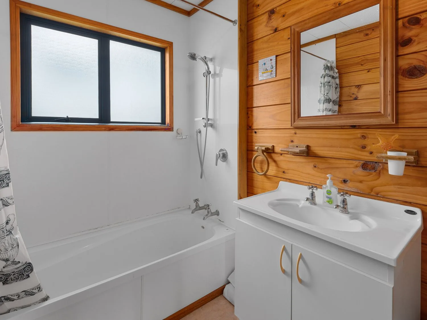 Un baño con bañera y ducha junto a un lavabo y un espejo.