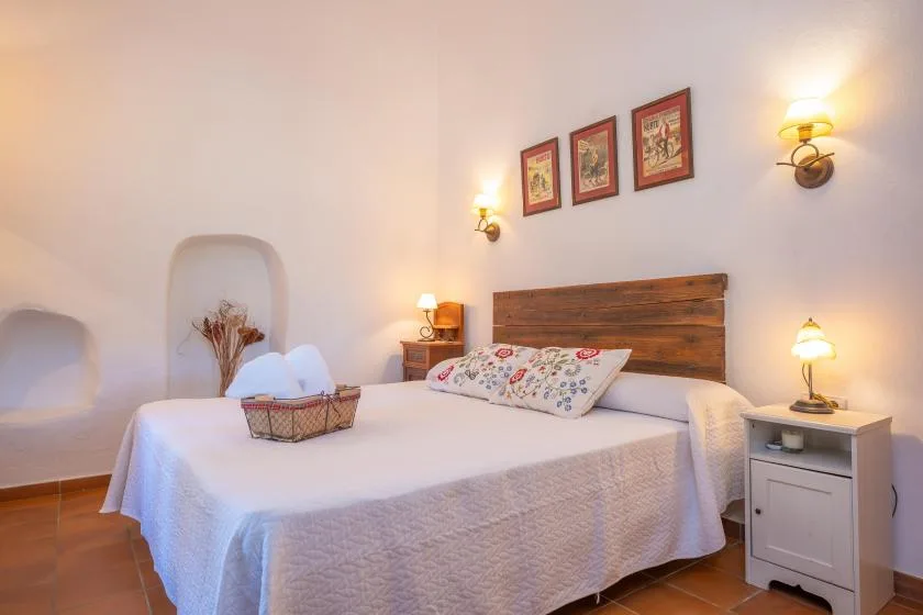 A bedroom with a bed, patterned pillows, and wooden headboard.