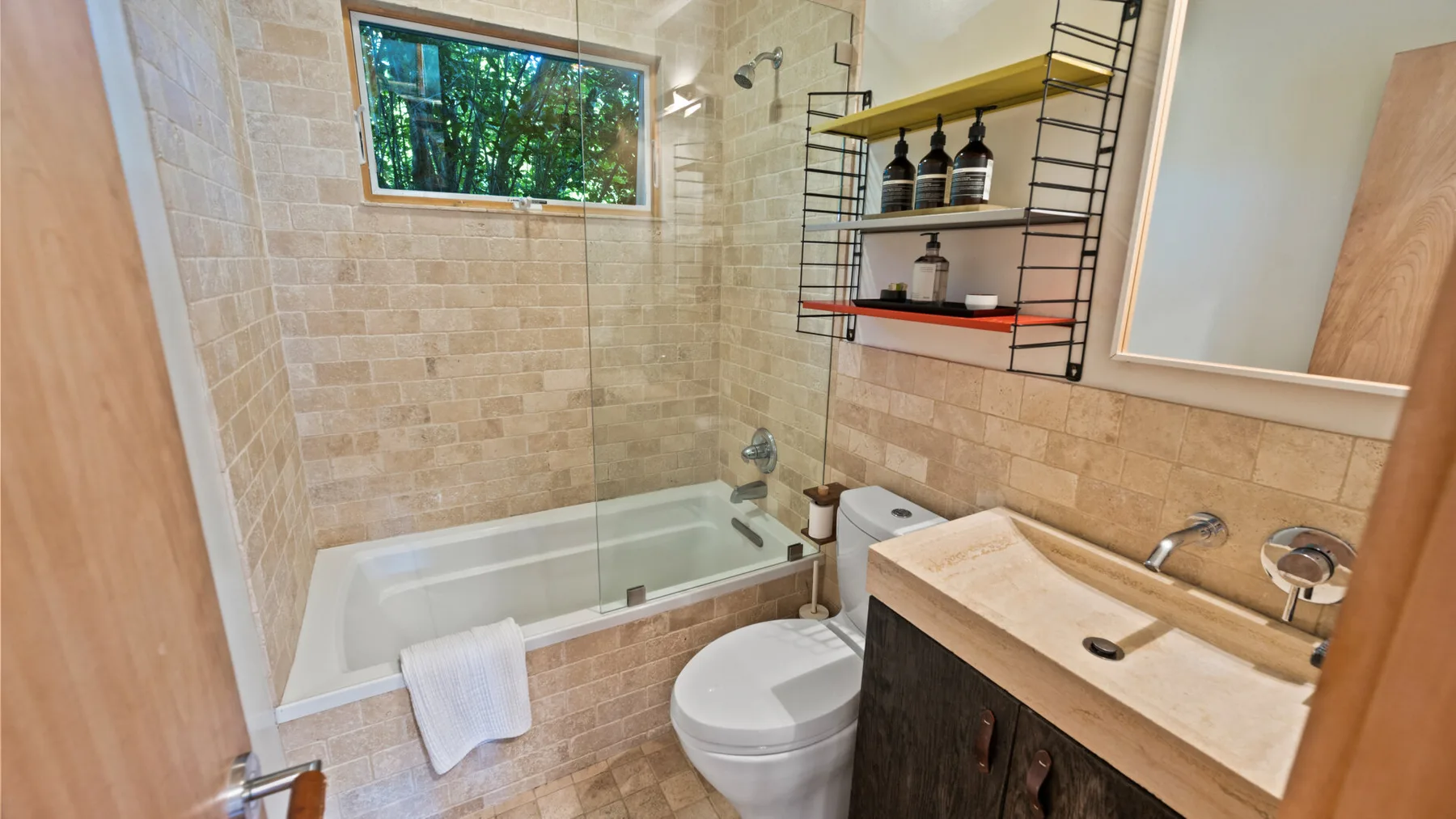 Un baño con azulejos, bañera, inodoro y lavabo.