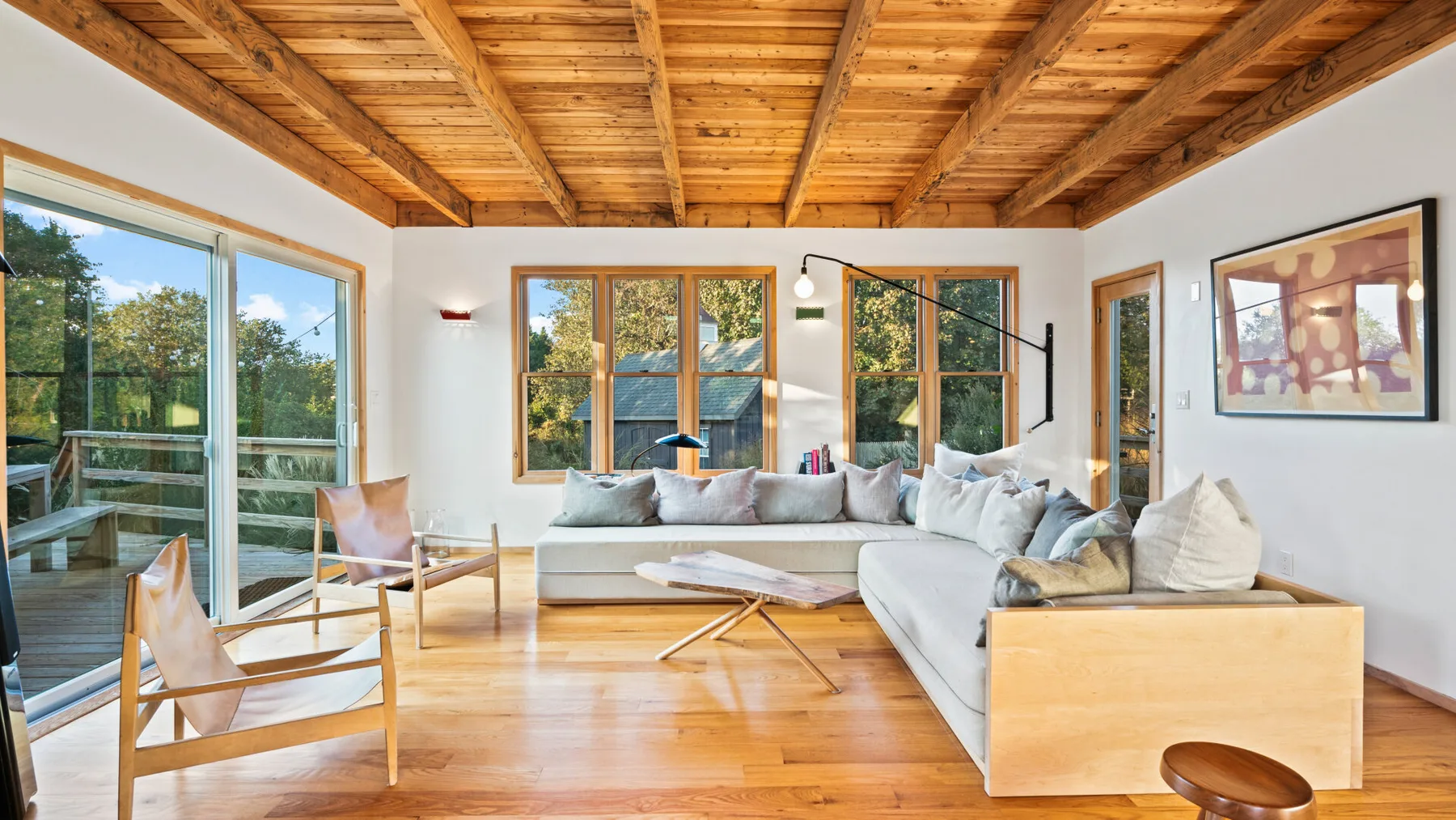 Una sala luminosa tiene una amplia zona de asientos bajo un techo de madera.