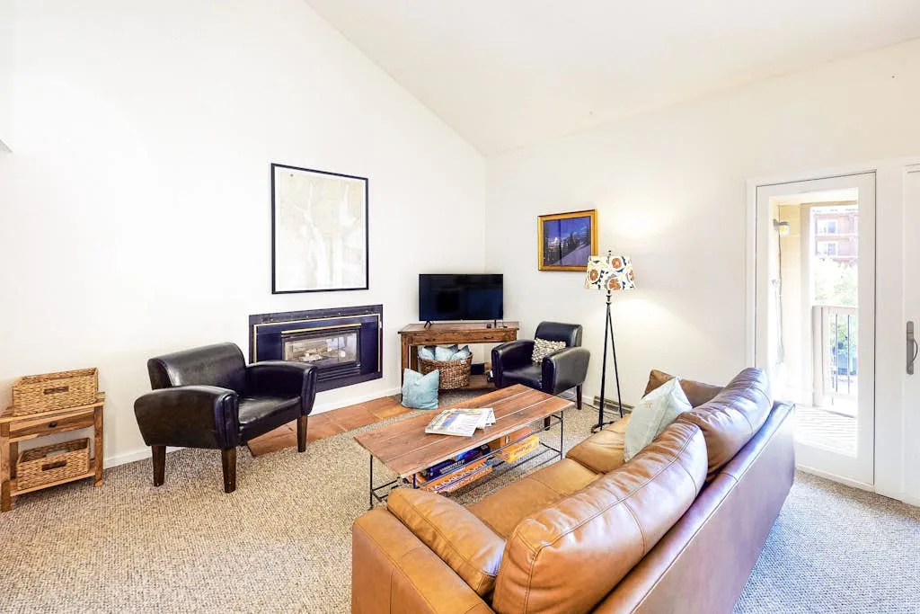 A living room with seating arranged around a coffee table and television.