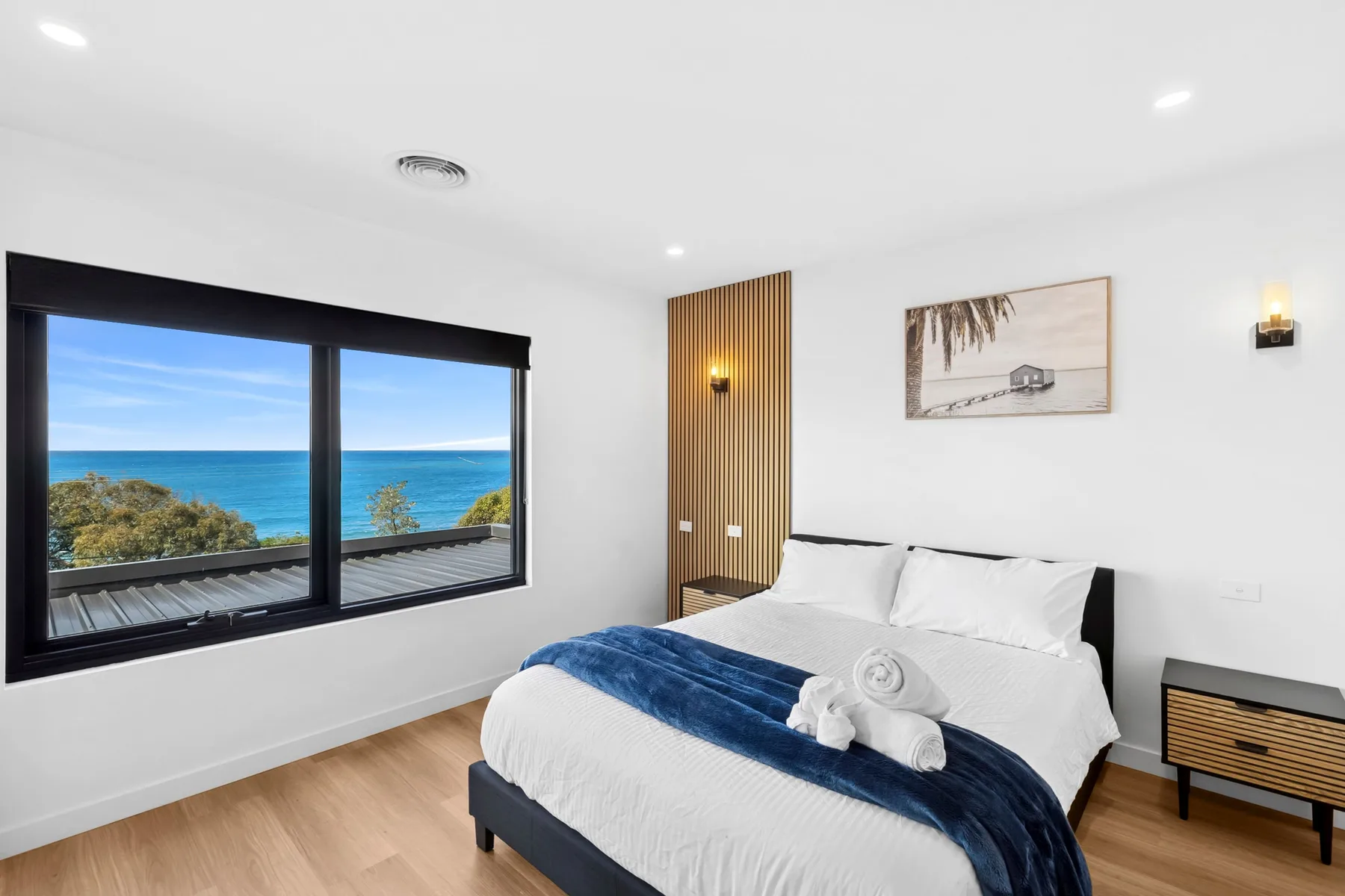 Un dormitorio con una ventana grande con vistas al océano.