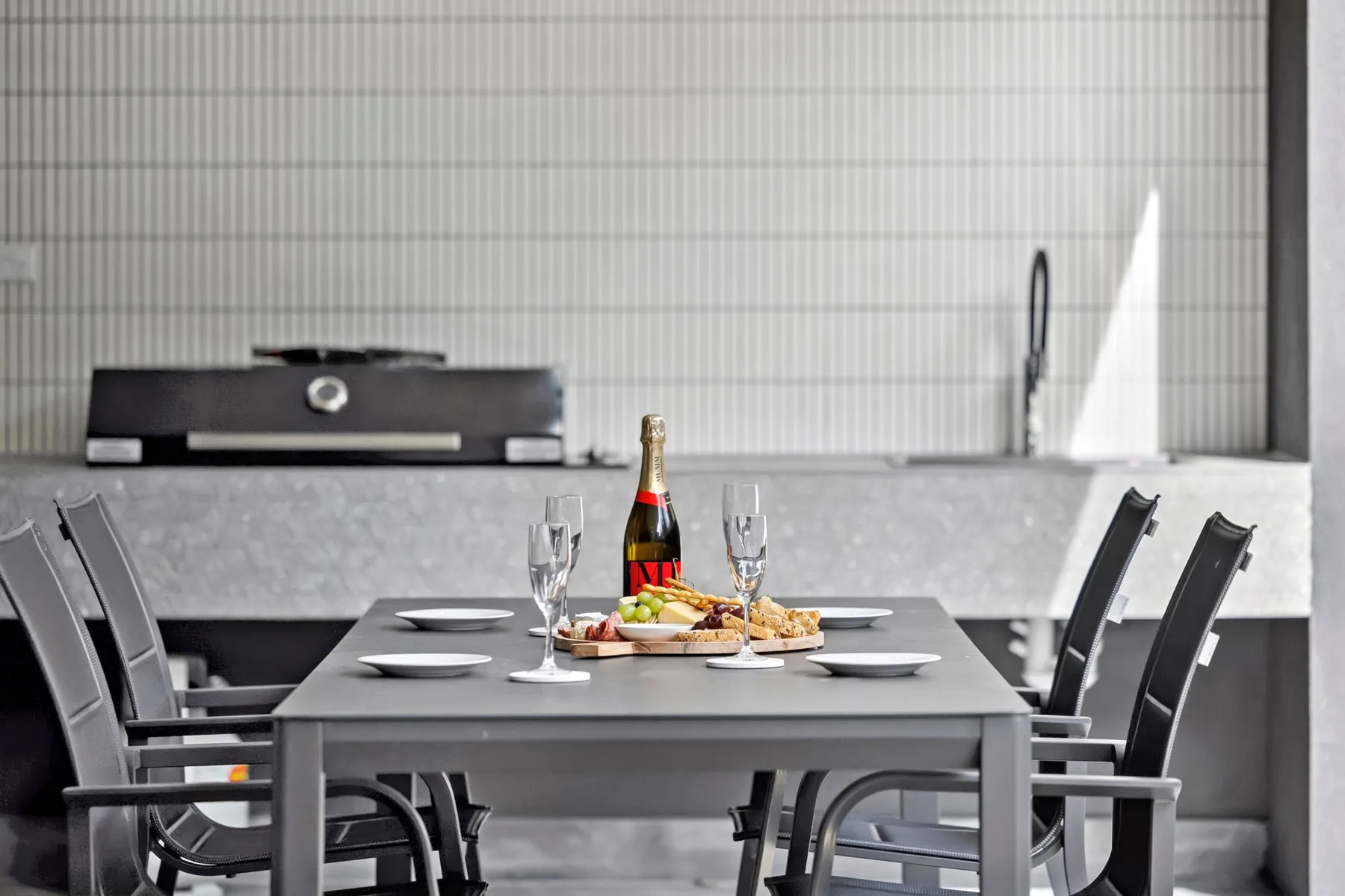 Un comedor con la mesa puesta y asientos oscuros.