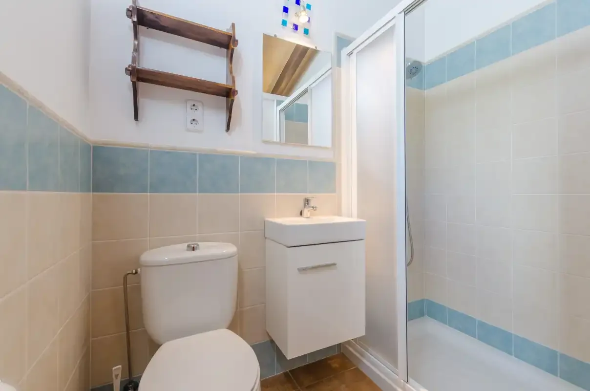 A tiled bathroom with a sink, toilet, and shower.