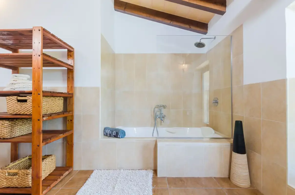 A tiled bathroom with a bathtub, shower, and wooden shelving.