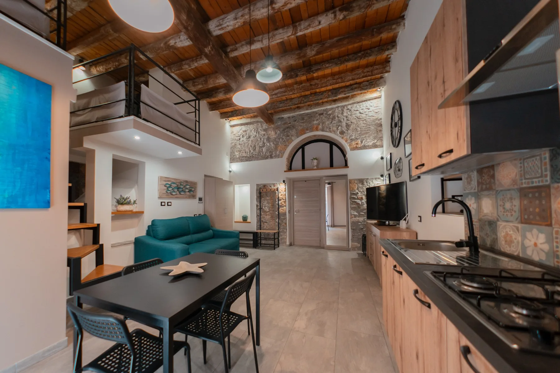 Open-plan living area with a dining table, seating, and a kitchen.