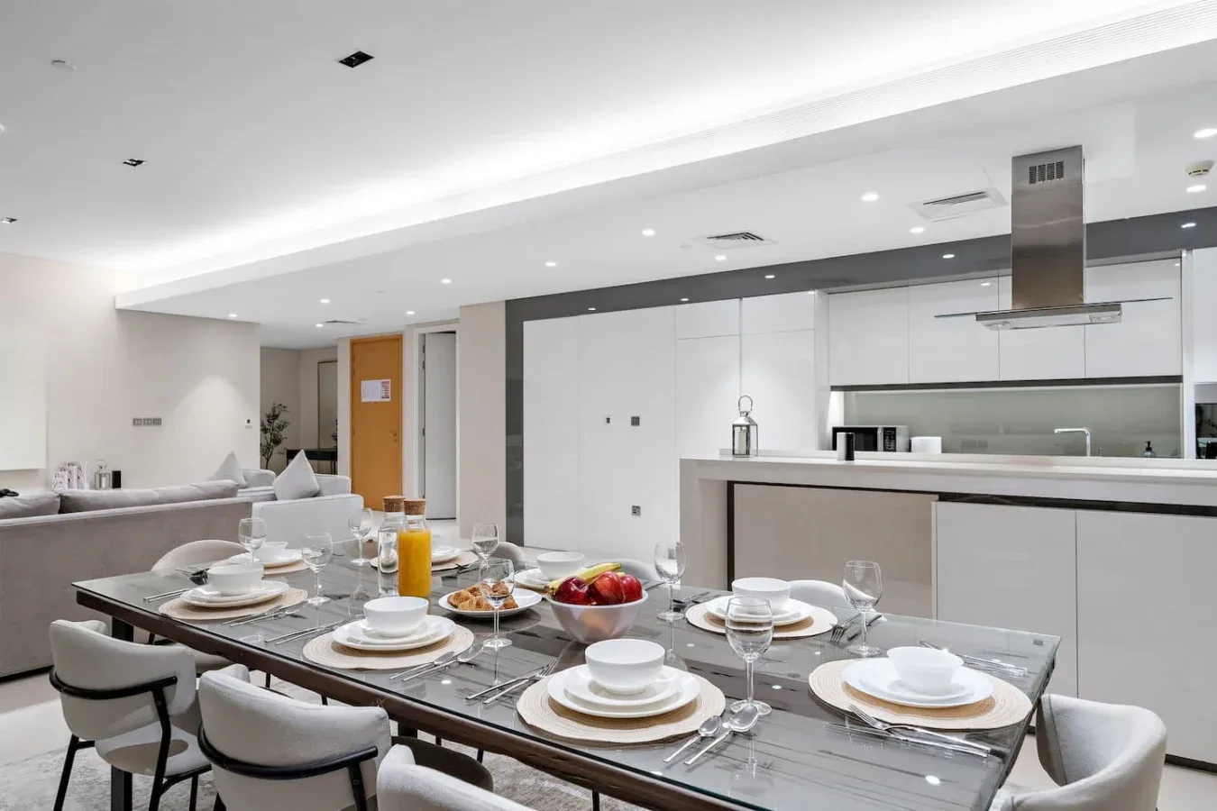 Comedor con la mesa puesta junto a una cocina abierta.
