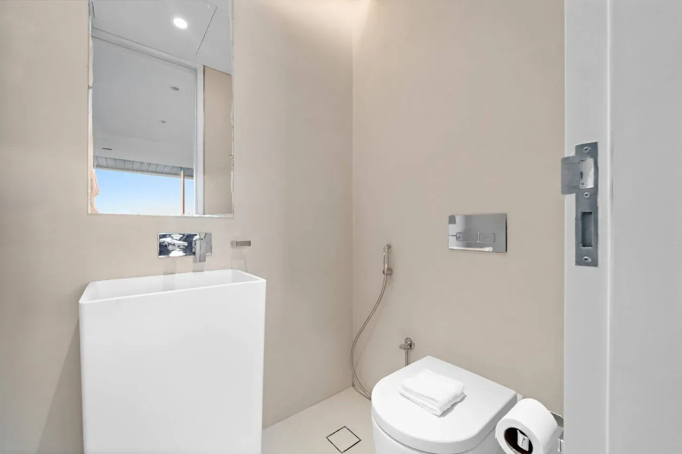 Un baño con lavabo, inodoro y accesorios en la pared.