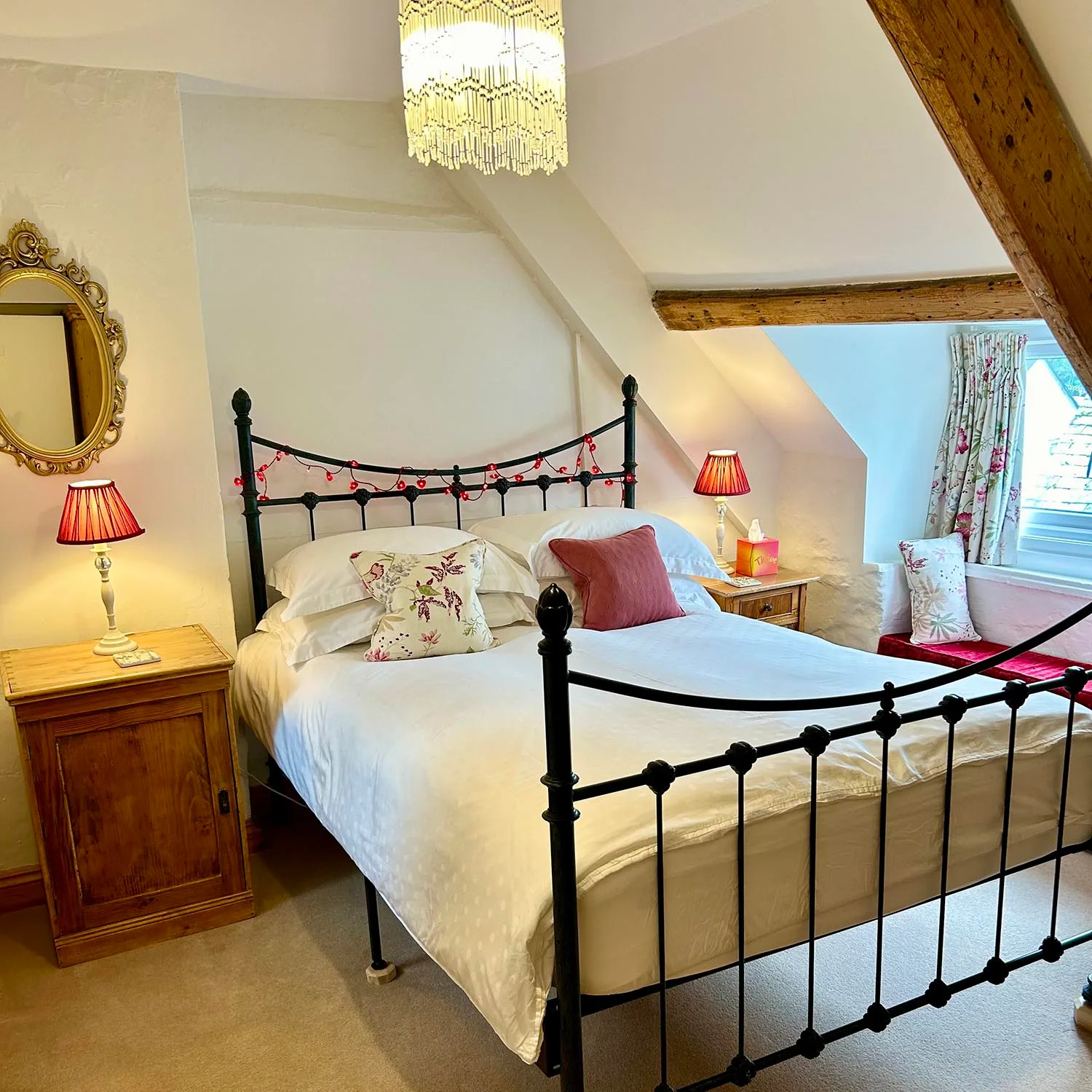 Thrift double bedroom with a cast-iron bed and exposed wooden beams