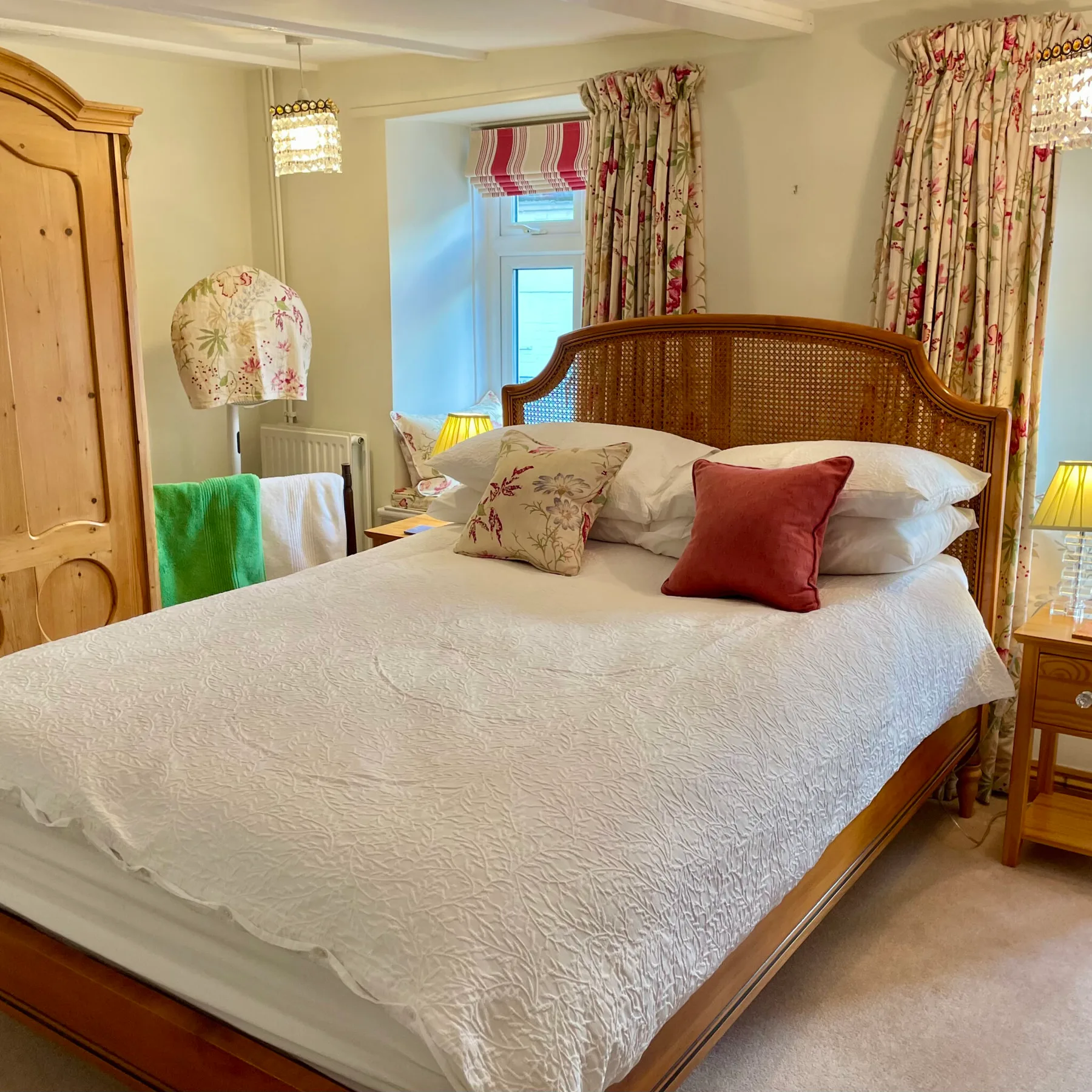 Tamarisk double bedroom with a wooden cane headboard and floral furnishings