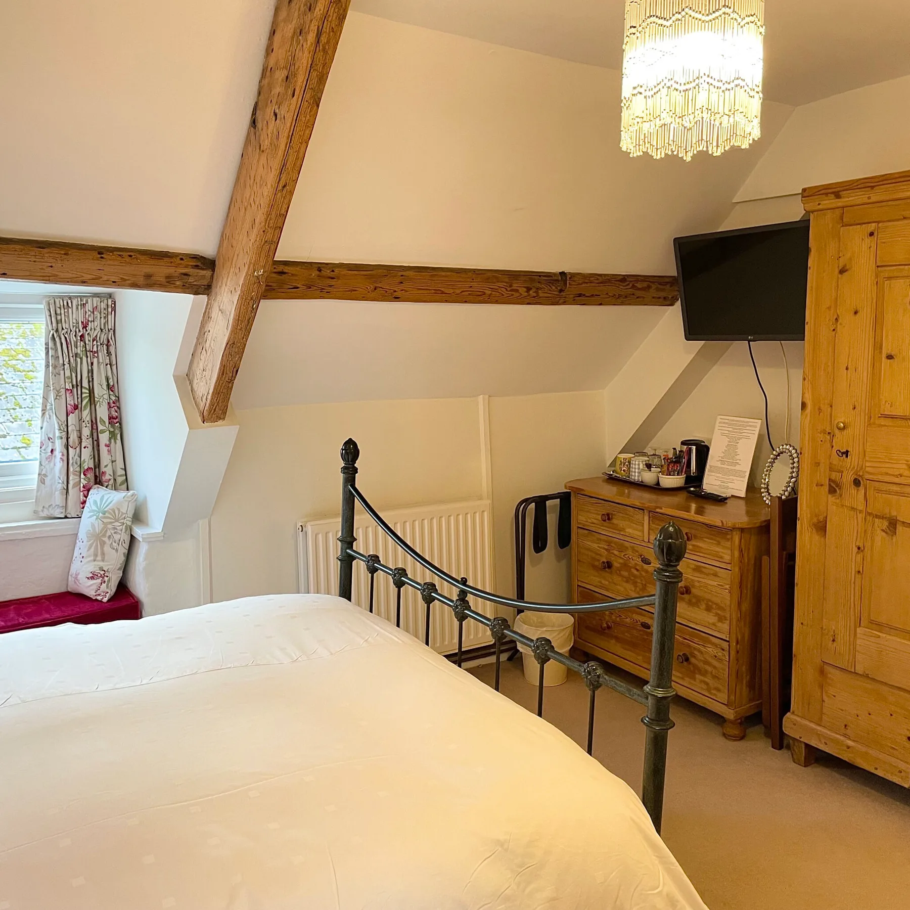 Thrift bedroom with exposed beams, pine furniture and refreshment facilities