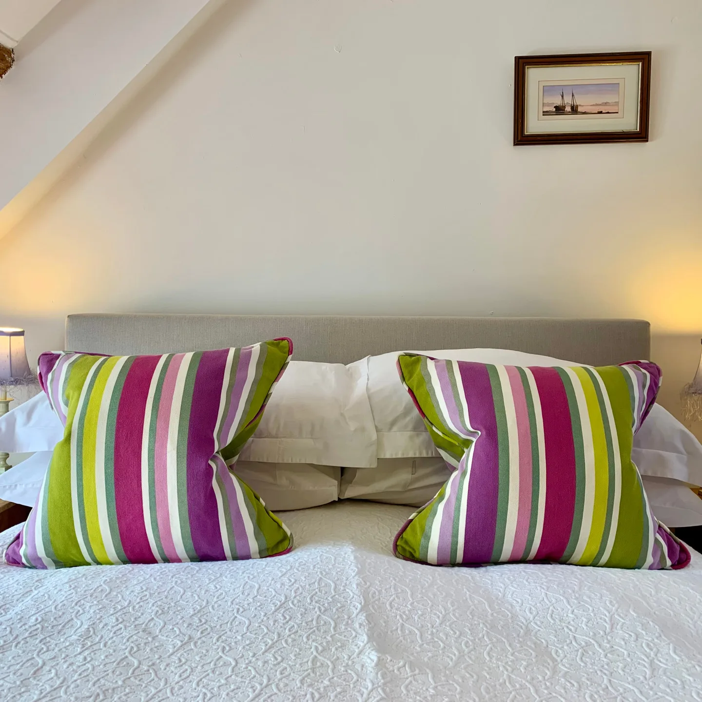Marram double bed with colourful striped cushions and white cotton bedding