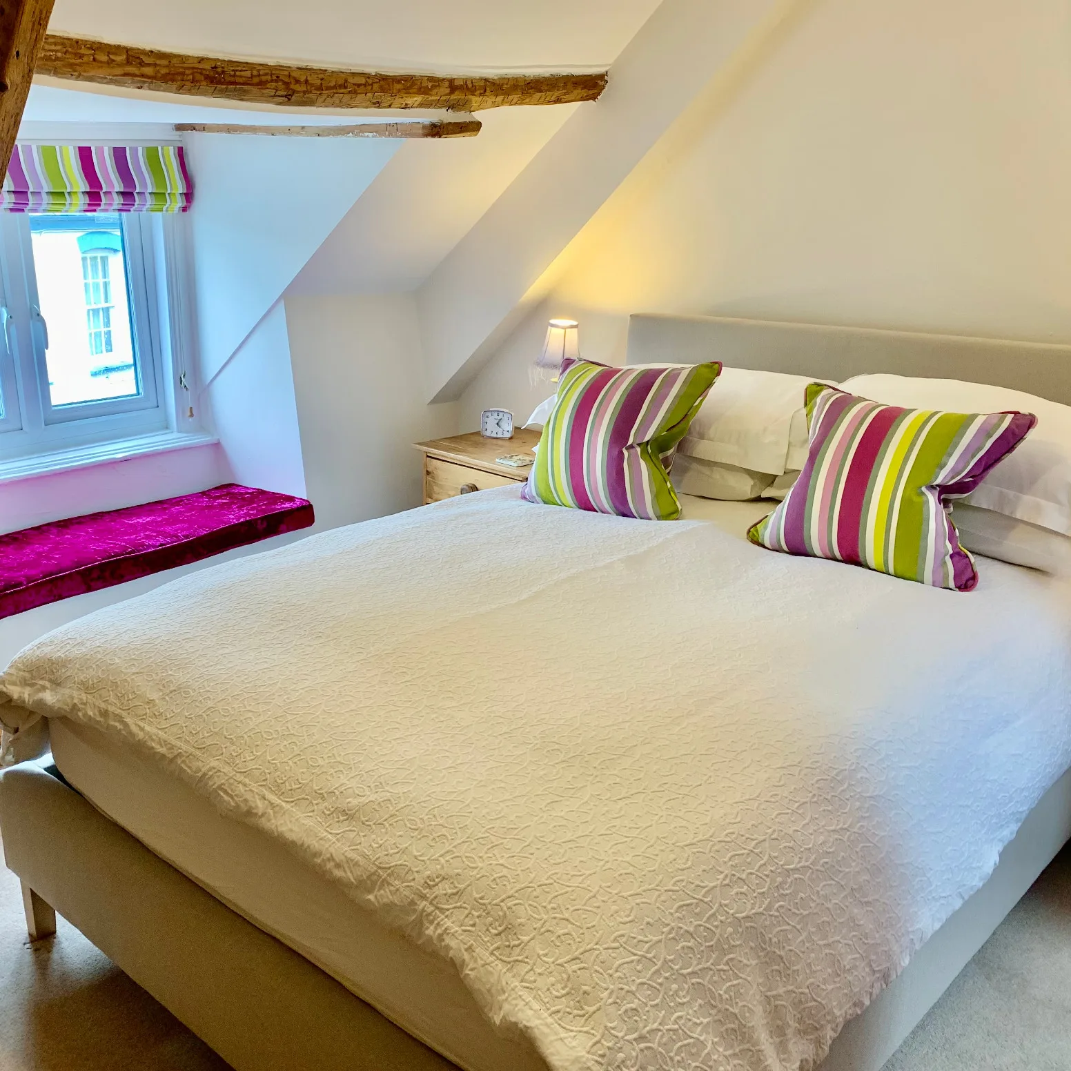 Marram double bedroom with exposed beams and colourful striped cushions