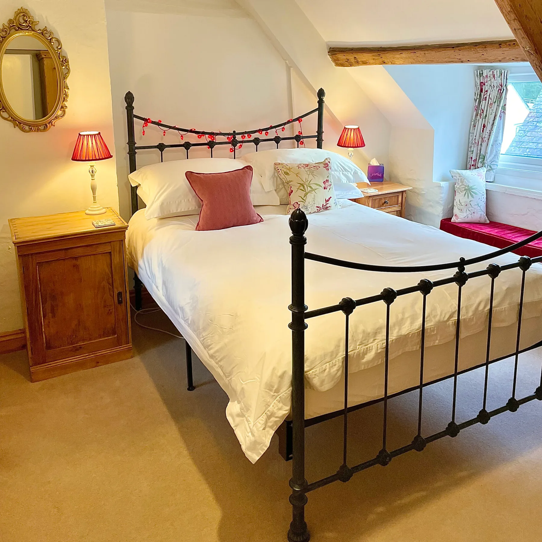 Double bedroom at Cyntwell with a cast-iron bed and exposed beams