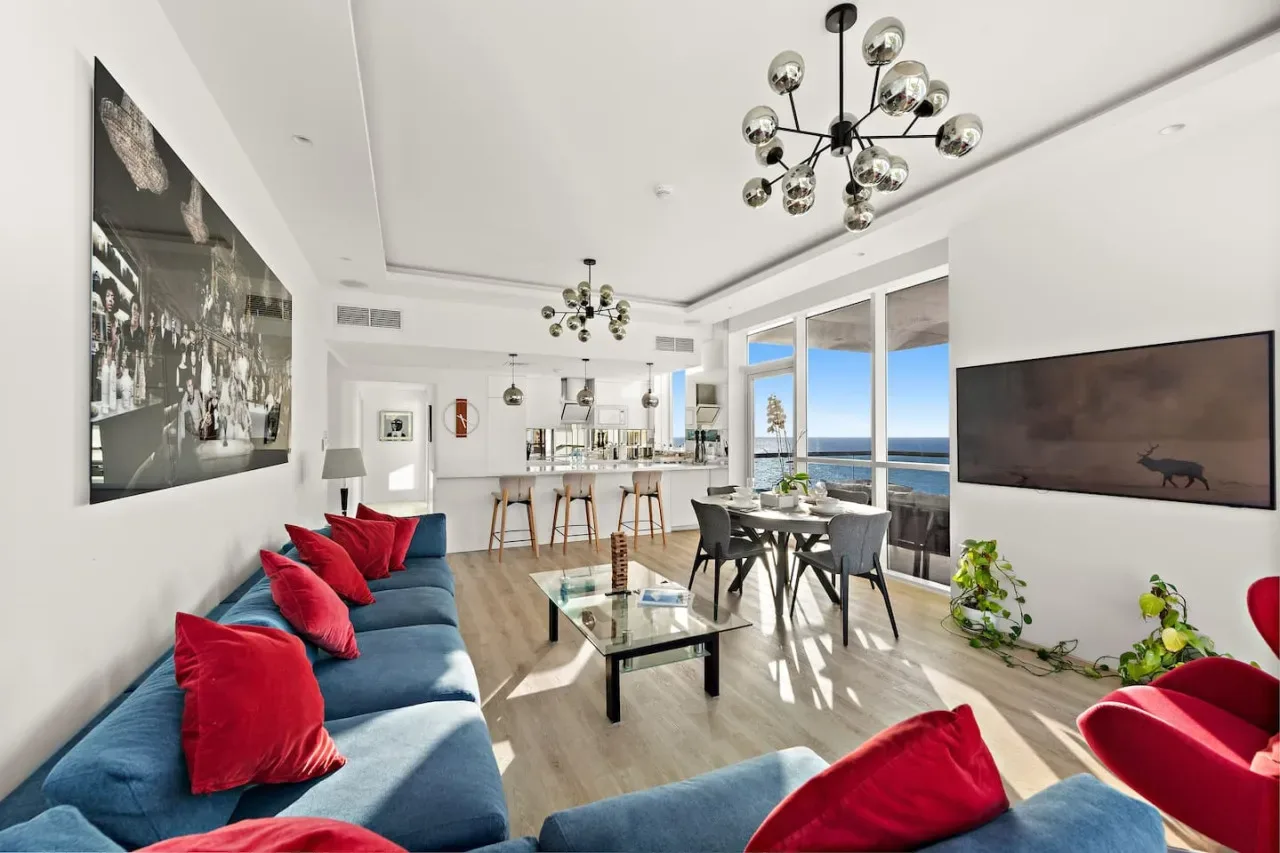 Una luminosa sala de estar y comedor diáfanos, con grandes ventanas frente al mar.