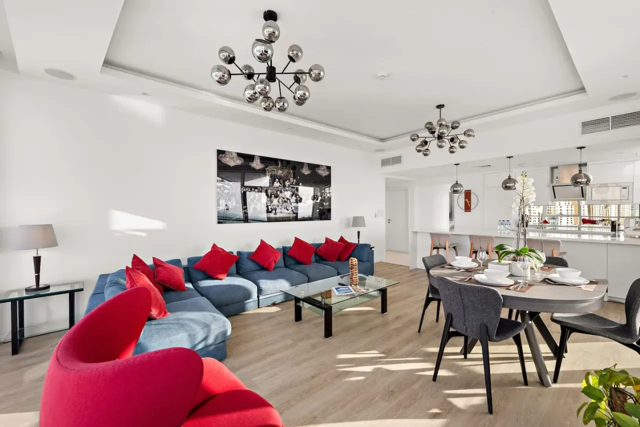 Una luminosa sala de estar y comedor diáfana, con asientos azules y una mesa puesta.