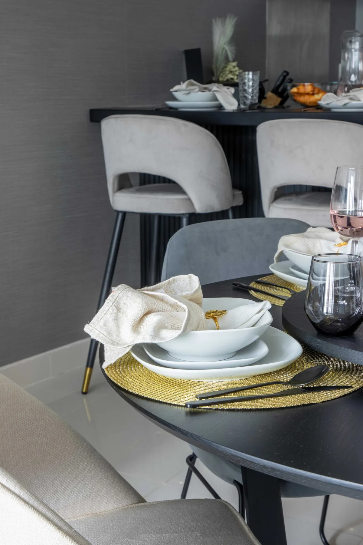Comedor con una mesa puesta y asientos tapizados.