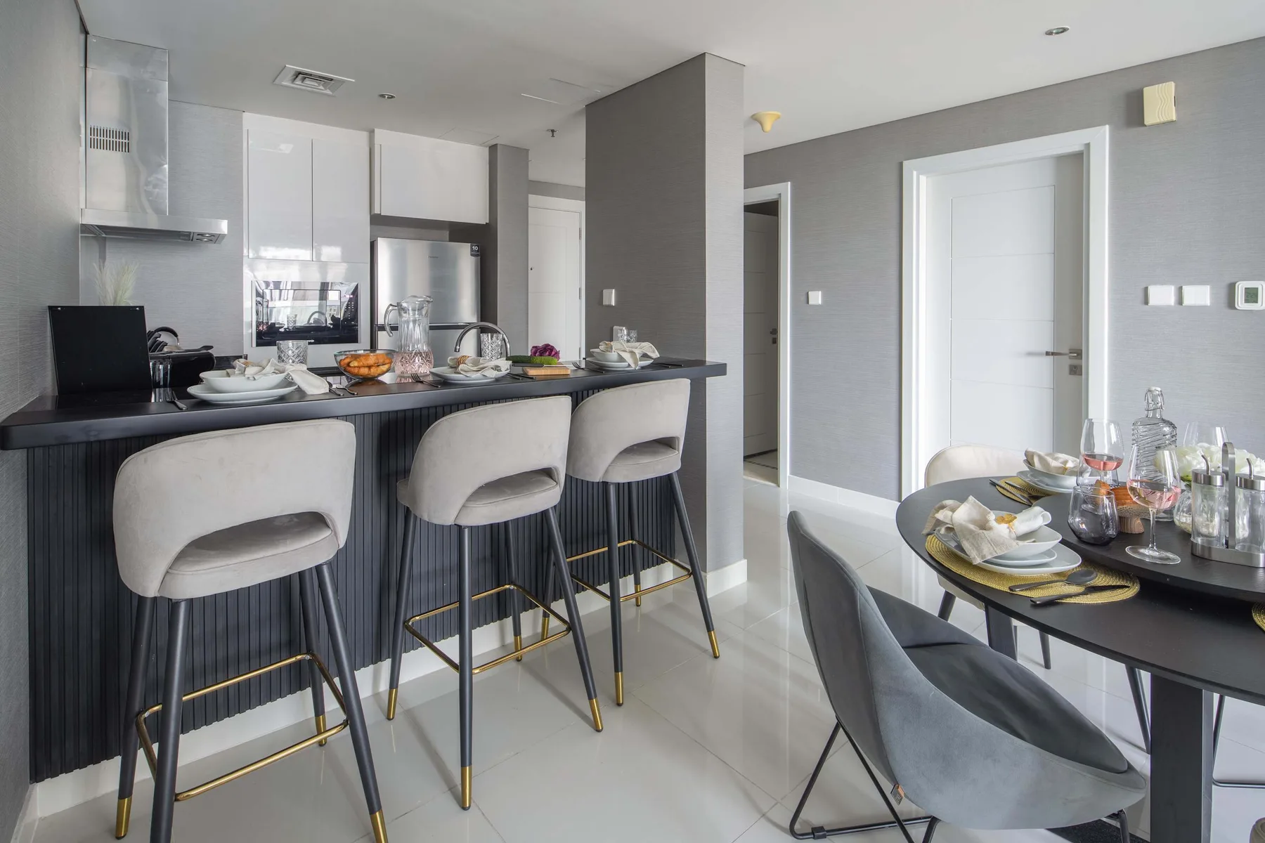 Cocina y comedor modernos con una barra y una mesa puesta.