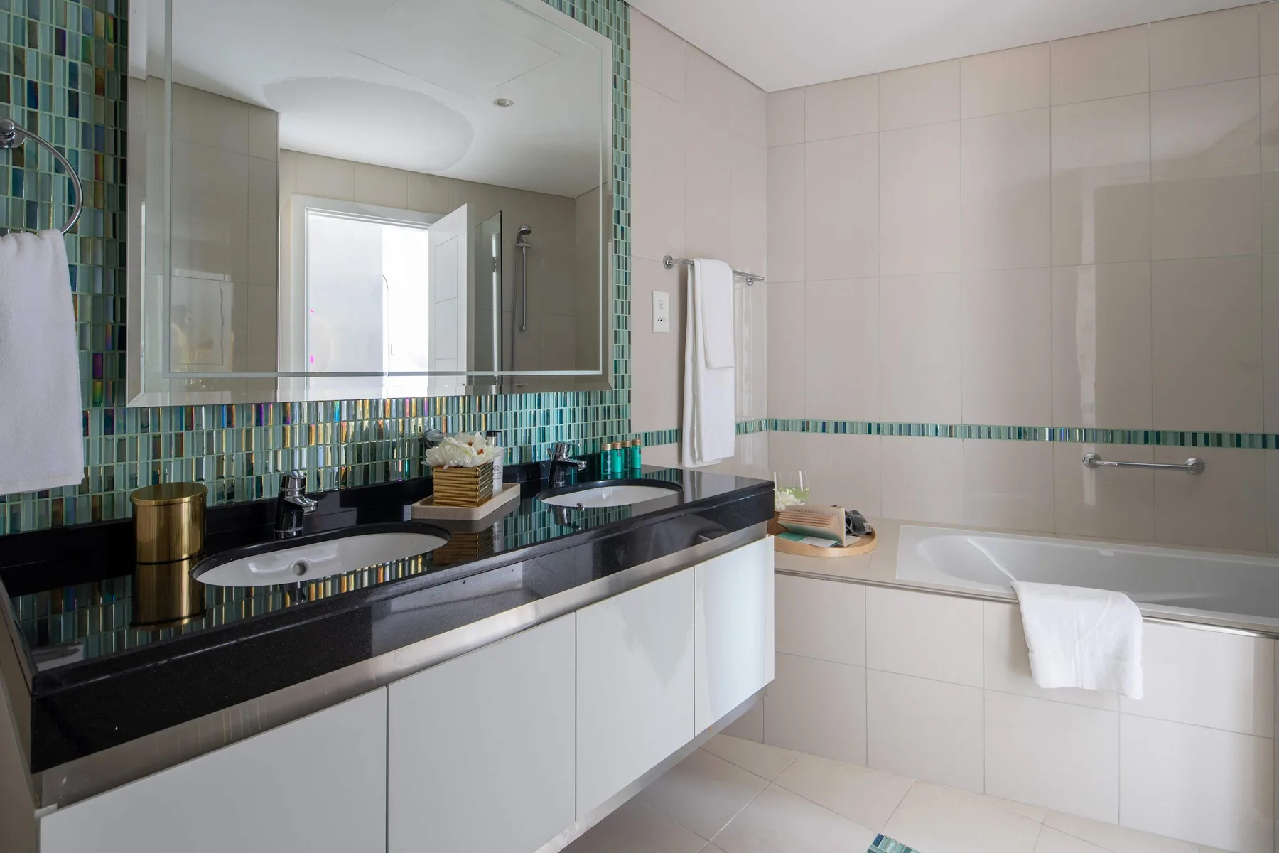 Un baño alicatado con un tocador largo y una bañera.