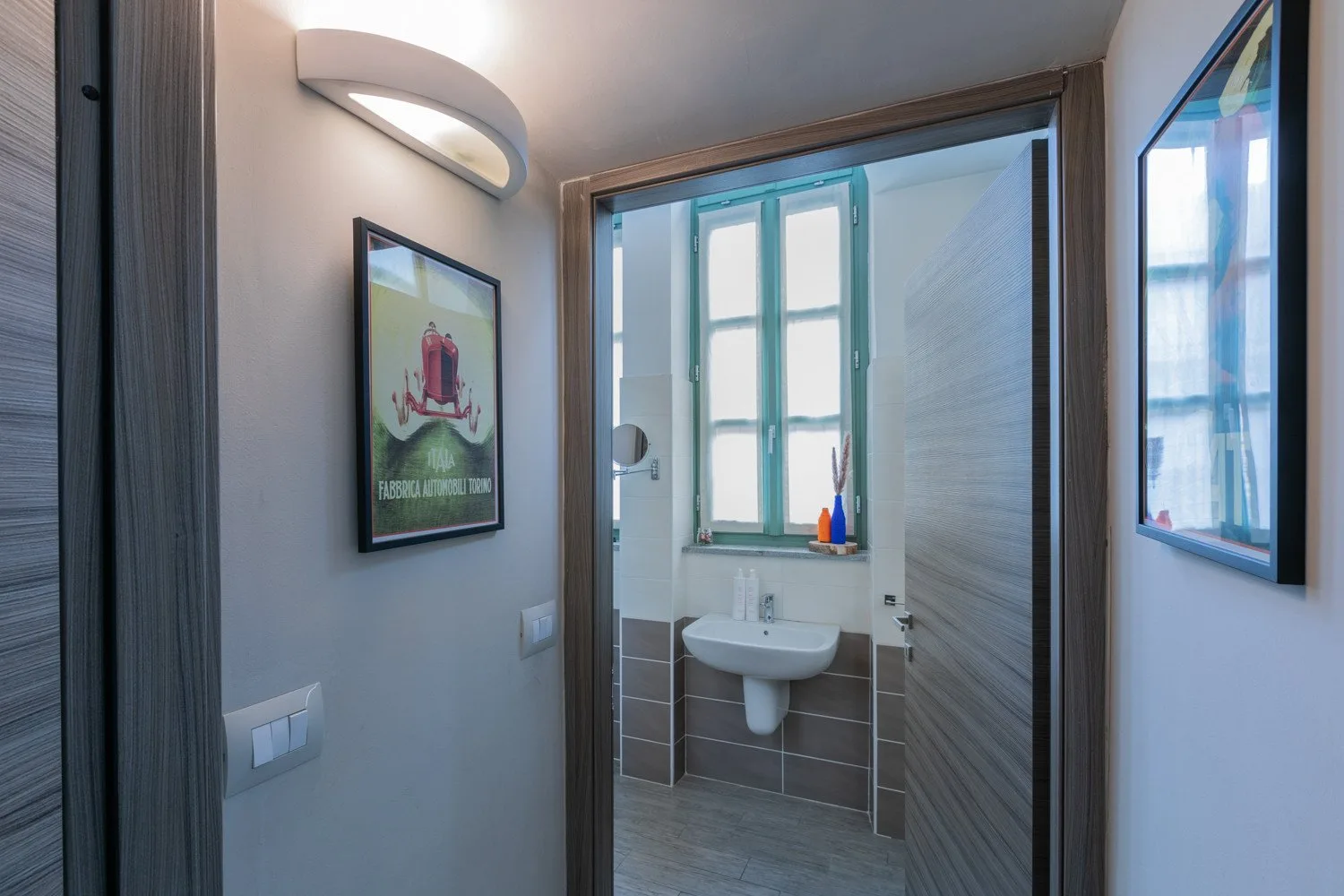 Un baño con un lavabo y una ventana encima.