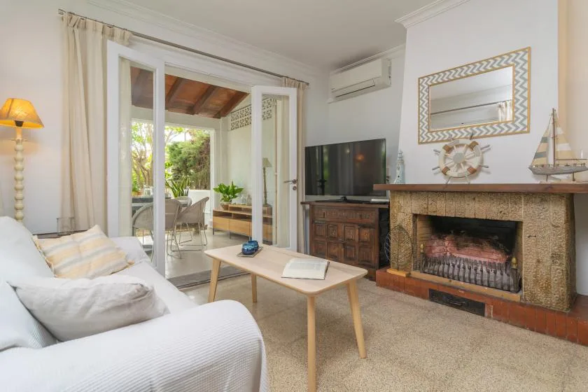 Sala de estar con asientos, una mesa de centro y una chimenea.