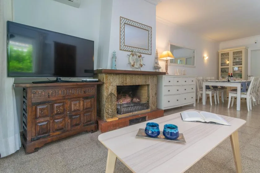 Una sala de estar con televisor, chimenea y zona de asientos.