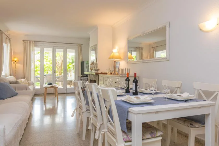 Una luminosa sala de estar y comedor con la mesa puesta y asientos.