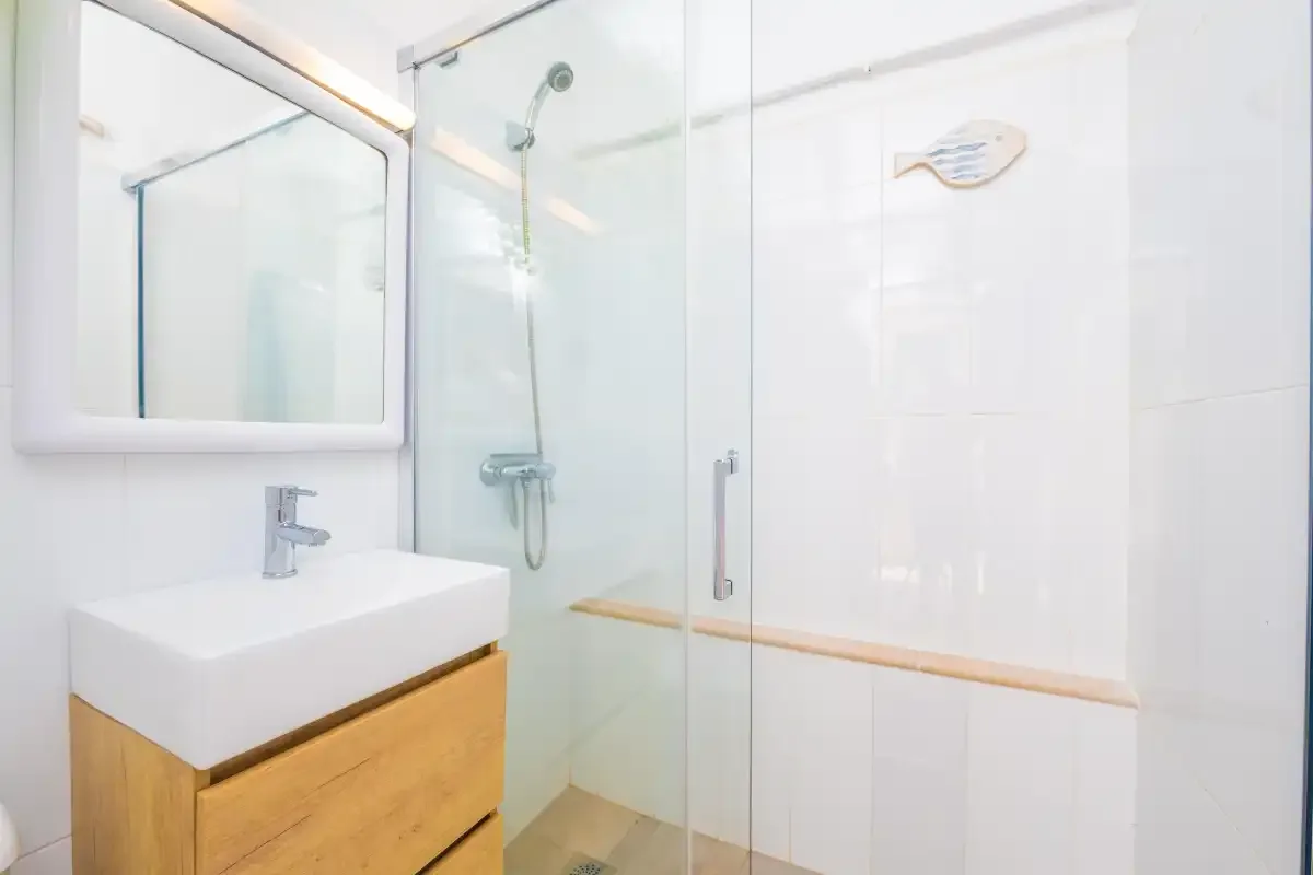 Un baño luminoso con lavabo y ducha.