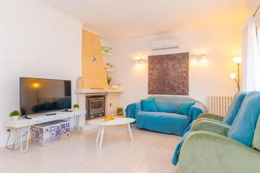 Una sala de estar con asientos azules, una chimenea y un televisor.