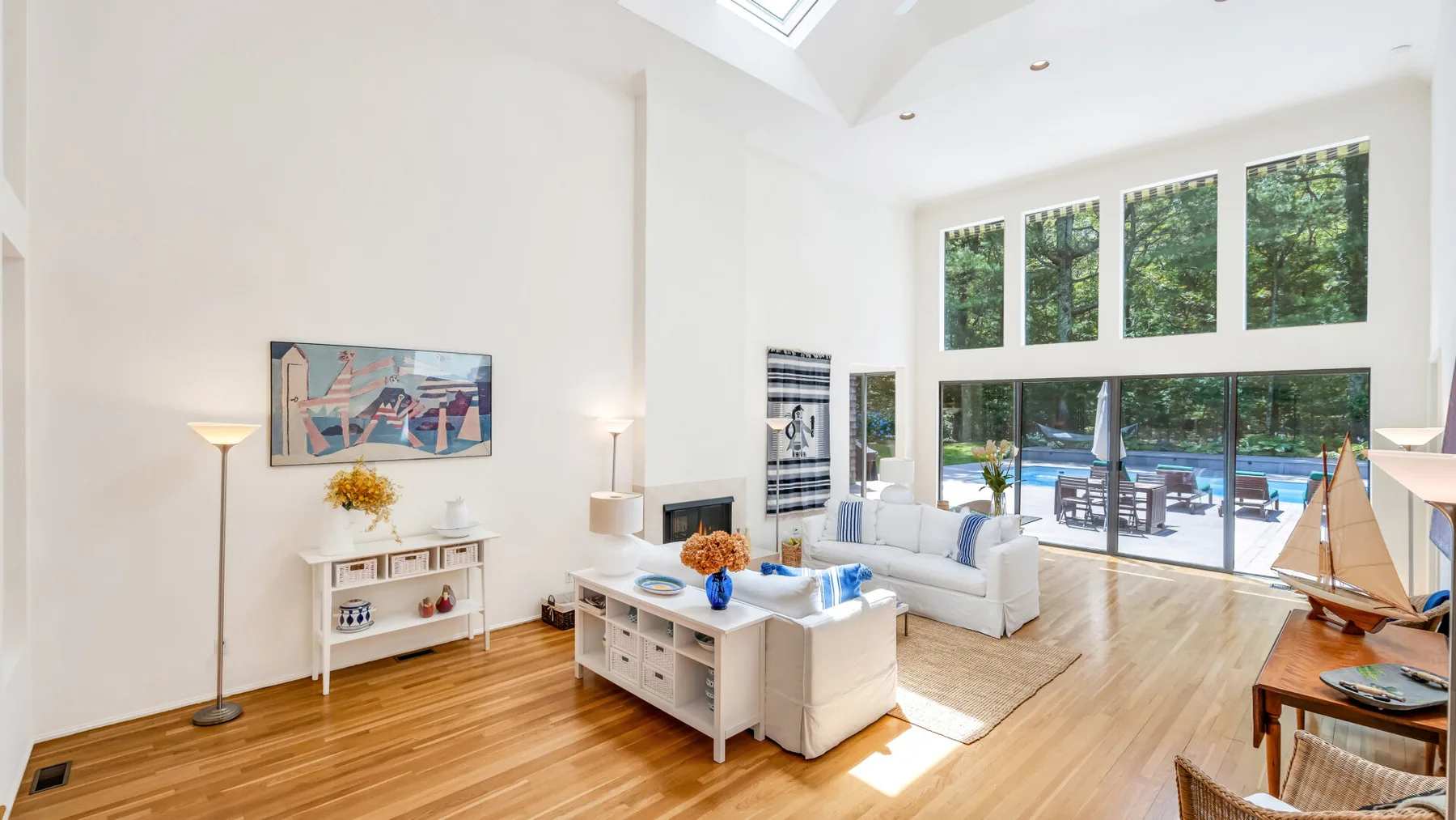 Una sala luminosa con asientos y grandes ventanas con vista a una piscina.