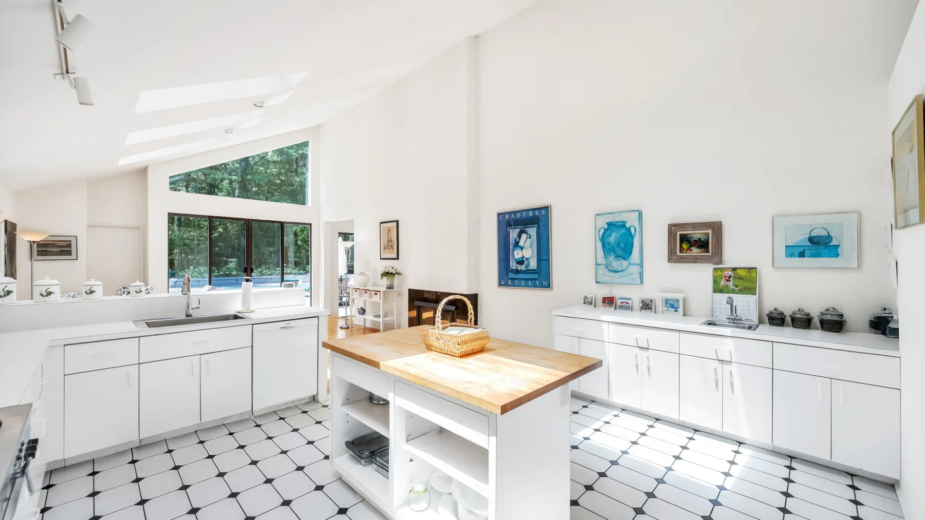 Una cocina luminosa con armarios blancos, una isla central y ventanales.