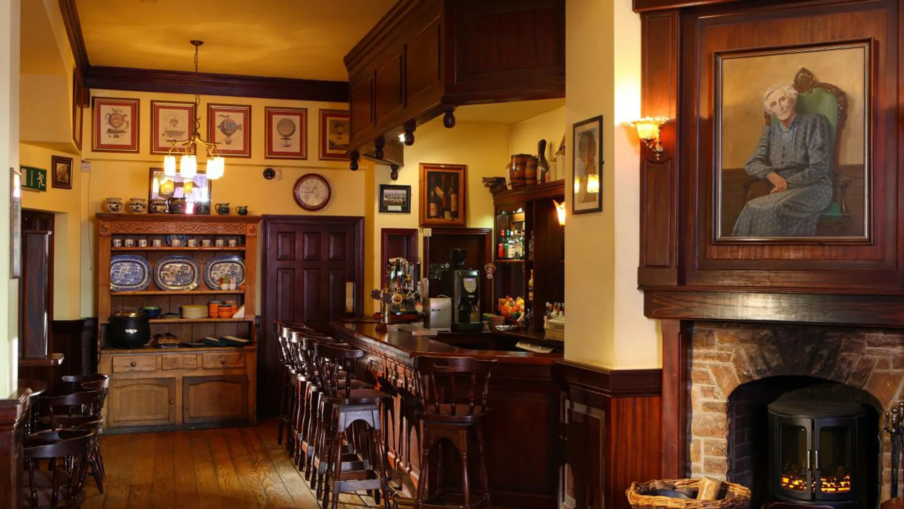 Traditional bar interior with wooden furnishings and a fireplace.