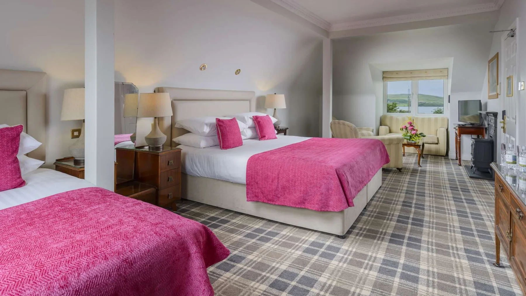 Guest room with two beds and a seating area by the window.