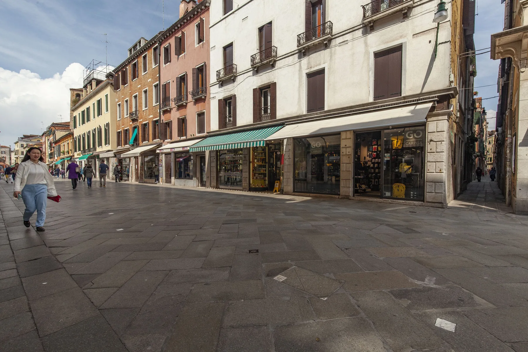 Una calle peatonal bordeada de tiendas y edificios de varias plantas.